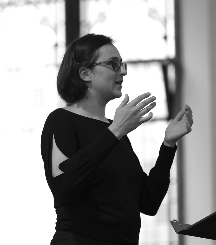 A woman with her hands raised in a conducting pose