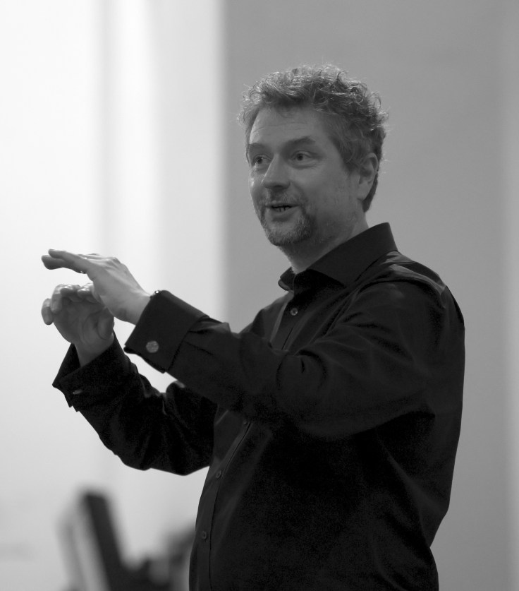A man with his arms raised in conducting style